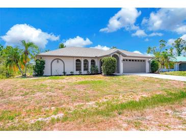 Charming single-story home with arched windows, a two-car garage, and well-maintained landscaping at 3510 Shawn St, Punta Gorda, FL 33980