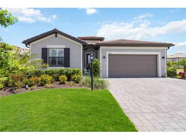 Charming one-story home with a well-manicured lawn, brick paved driveway, and two car garage at 5165 Coral Reef Way, Bradenton, FL 34211