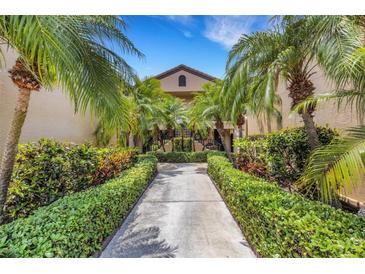 Inviting condo exterior featuring lush landscaping and palm trees lining the walkway to the entrance at 5632 Ashton Lake Dr # 5632, Sarasota, FL 34231