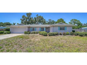 Charming one-story home with a well-manicured lawn, blue shutters, and an attached garage at 5706 10Th Avenue Dr W, Bradenton, FL 34209