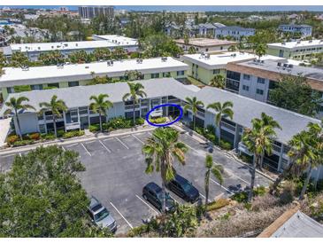 An aerial view of a condo building featuring multiple units and ample parking surrounded by tropical landscaping at 6713 Midnight Pass Rd # 4, Sarasota, FL 34242
