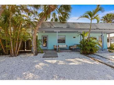 Charming, light-blue single-story home featuring a landscaped yard with white pebbles and an inviting front porch at 205 71St St # B, Holmes Beach, FL 34217