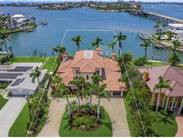 Aerial view of the Mediterranean-style home with lush landscaping, and waterfront access at 3576 San Remo Ter, Sarasota, FL 34239