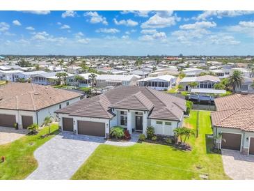 Beautiful single-story home with a well-manicured lawn, dark brown tiled roof, paver driveway and an attached three-car garage at 4312 Vasco St, Punta Gorda, FL 33950