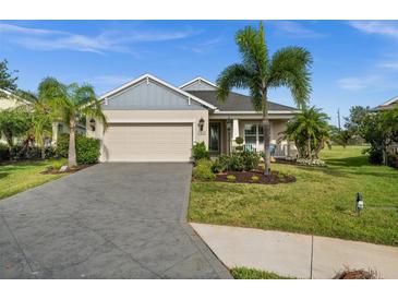 Charming single-story home with a well-manicured lawn, palm trees, and a two-car garage at 4542 Cedar Brush Ter, Sarasota, FL 34243