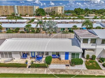 Charming villa featuring a covered patio with blue furniture and a well-maintained landscape at 5858 Midnight Pass Rd # 27, Sarasota, FL 34242