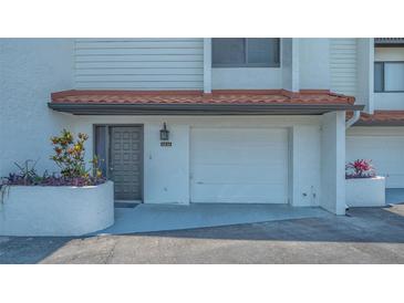 Charming townhouse featuring an attached one car garage and a welcoming front entrance with colorful landscaping at 6836 Midnight Pass Rd # 6836, Sarasota, FL 34242