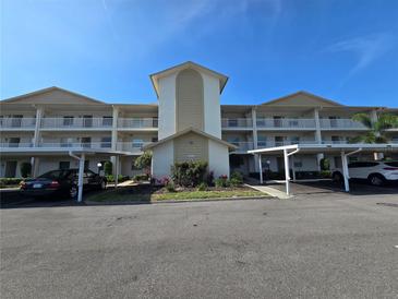 Condo exterior with a white facade, balconies, covered parking, and a well-maintained landscape at 7201 29Th Avenue W Dr # 306, Bradenton, FL 34209
