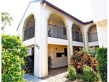 Condo exterior featuring a private balcony, and well maintained landscaping at 802 Capri Isles Blvd # 231, Venice, FL 34292