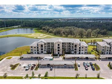 An aerial view of the condo complex with a pond, golf course and covered parking at 18114 Gawthrop Dr # 201, Bradenton, FL 34211