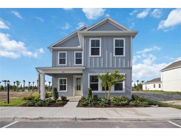 Charming two-story home with blue siding, a covered porch, and well-manicured landscaping at 204 Eagleston Ln, Lakewood Ranch, FL 34240