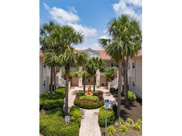 Beautiful courtyard view with a central fountain, palm trees, and well-maintained landscaping in a condominium complex at 4244 Central Sarasota Pkwy # 726, Sarasota, FL 34238