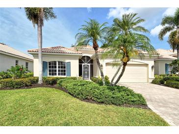 Charming single-story home with a well-manicured lawn, mature palm trees, and a tile roof at 7124 Rue De Palisades # 21, Sarasota, FL 34238