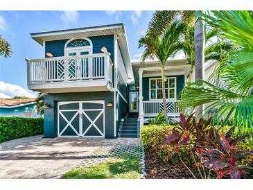 Charming two-story home with a delightful balcony, beautiful landscaping, and a well-kept lawn at 307B 63Rd St, Holmes Beach, FL 34217
