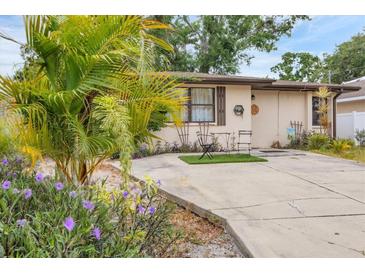 Charming single-story home featuring lush landscaping and a cozy outdoor seating area, perfect for enjoying the Florida sunshine at 4023 Chestnut Ave, Sarasota, FL 34234