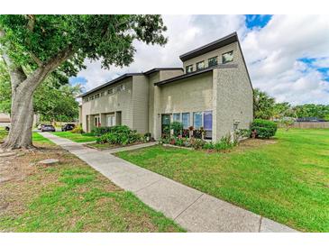 Charming townhome featuring mature landscaping and a welcoming entryway at 4381 Sandner Dr, Sarasota, FL 34243