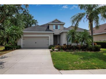 Charming single-Gathering home featuring a well-manicured lawn, mature palm trees, and a two-car garage at 5036 Brickell Park Cv, Bradenton, FL 34211