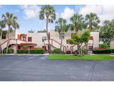 Condo complex boasts lush landscaping with mature palm trees and a well-maintained facade at 523 Spring Lakes Blvd, Bradenton, FL 34210