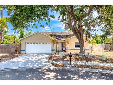 Charming one-story home featuring an attached garage, mature landscaping, and a welcoming front porch at 5623 Wilde Oak Way, Sarasota, FL 34232
