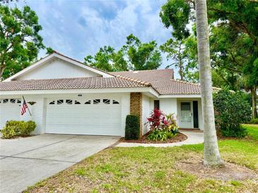 Charming single-story home with a well-maintained lawn, a two-car garage, and beautiful landscaping at 5810 Garden Lakes Palm, Bradenton, FL 34203