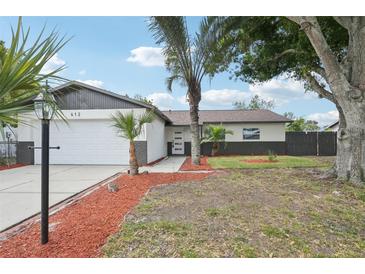Charming single-story home features a well-maintained lawn, palm trees, and an attached two-car garage at 612 65Th W Ave, Bradenton, FL 34207