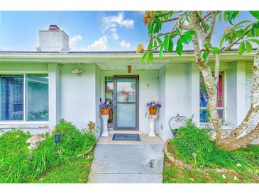 Inviting entrance with decorative plants, stone columns, and a charming tree at 6627 Heritage Ln, Bradenton, FL 34209