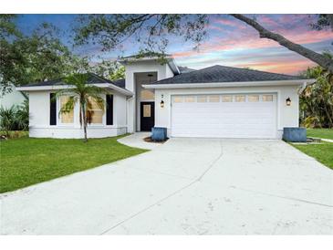 Charming one-story home with a well-maintained lawn and two car garage at 7 Arbor Oaks Dr, Sarasota, FL 34232