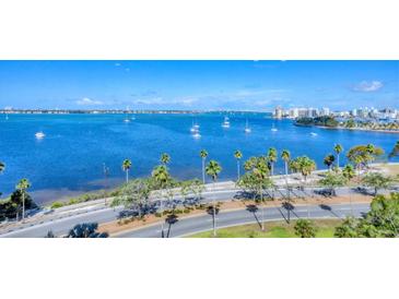 Expansive water view with sailboats on the bay, palm trees lining the shore, and city skyline in the background at 770 Palm Avenue # 903, Sarasota, FL 34236