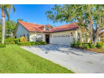 Charming single-story home with a red tile roof, lush landscaping, and a spacious two-car garage at 4517 Las Brisas Ln, Sarasota, FL 34238