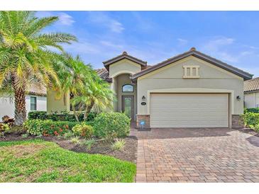 Charming single-story home with a brick driveway, lush landscaping and two-car garage at 148 Wandering Wetlands Cir, Bradenton, FL 34212