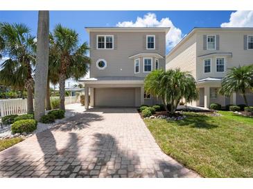 Charming two-story home with a brick driveway and well-manicured landscaping, creating a welcoming curb appeal at 215 65Th St, Holmes Beach, FL 34217