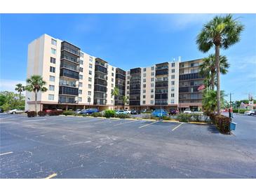 Multi-story condo building with ample parking, balconies, and mature palm trees against a sunny sky at 2901 26Th W St # 312, Bradenton, FL 34205