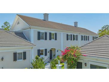 Elegant two-story home with dark shutters and lush landscaping in a well-maintained yard at 33 Bishops Court Rd # 118, Osprey, FL 34229