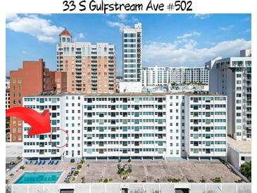 Condo building with pool and lounge chairs with building in sunny location at 33 S Gulfstream Ave # 502, Sarasota, FL 34236