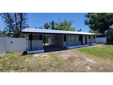 Charming single story home with a metal roof, carport and white fencing at 4210 Baird St, Sarasota, FL 34232