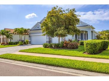 Charming single-Gathering home with a lush, green lawn and a well-manicured garden under the mature tree at 523 Wildlife Gln, Bradenton, FL 34209