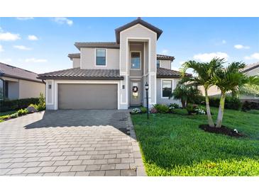Beautiful two-story home featuring a well-manicured lawn, a paved driveway, and a neutral color scheme at 5333 Coral Reef Way, Bradenton, FL 34211