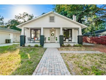 Charming home with inviting front porch, brick pathway and black and white color scheme at 720 37Th W St, Bradenton, FL 34205