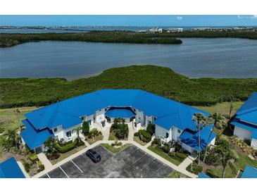 Waterfront condo complex with blue roof and lush landscaping overlooking bay at 939 Sandpiper Cir, Bradenton, FL 34209
