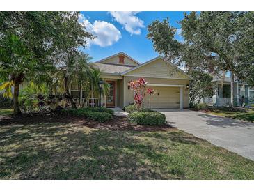 Charming single-story home featuring a manicured lawn, mature trees, and an attached two-car garage at 12149 Forest Park Cir, Bradenton, FL 34211