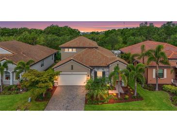 Charming single-Gathering home with a well-manicured lawn, paver driveway, tile roof, and tropical landscaping at 2745 62Nd E Ave, Ellenton, FL 34222