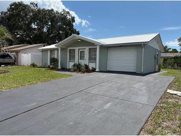 Charming single-story home with a well-maintained lawn and a paved driveway leading to an attached garage at 4833 Dogwood St, New Port Richey, FL 34653