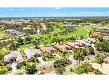 Stunning aerial view of home, showcasing the golf course and lush landscaping at 52 Grande Fairway, Englewood, FL 34223