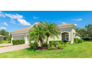Inviting single-story home featuring a lush lawn, verdant plantings, and attractive neutral-toned exterior paint at 5450 Fairfield Blvd, Bradenton, FL 34203