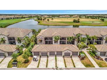 Aerial view of an elegant townhome community, showcasing tile roofs, garages, and golf course views at 5624 Palmer Cir # 101, Bradenton, FL 34211
