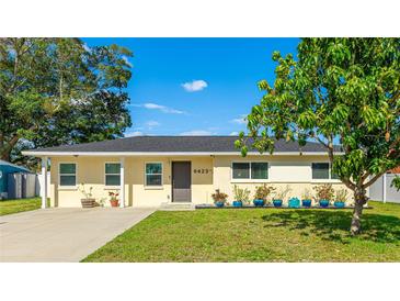 Charming single-story home featuring a well-maintained lawn and tidy landscaping with beautiful blue planters at 6423 Georgia Ave, Bradenton, FL 34207