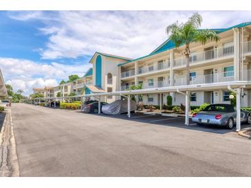 Exterior view of the condo units with parking spots underneath and landscaped grounds at 7301 29Th Avenue W Dr # 108, Bradenton, FL 34209