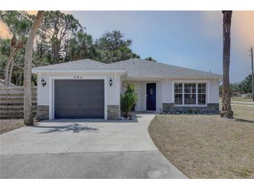 Charming single-story home with a gray roof, gray garage door, and a well-maintained front yard at 904 Winter Garden Dr, Sarasota, FL 34243