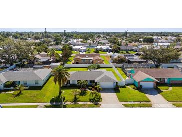 An aerial view of a well-maintained single Gathering home with a lush green lawn in a quiet neighborhood at 913 64Th W St, Bradenton, FL 34209