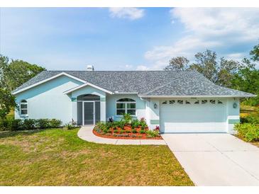 Charming single-story home features a well-manicured lawn, a two-car garage, and colorful landscaping at 10001 289Th E St, Myakka City, FL 34251